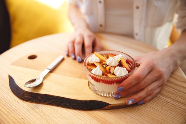 Bebouwd beeld van roodharige jonge dame die dessert eet.