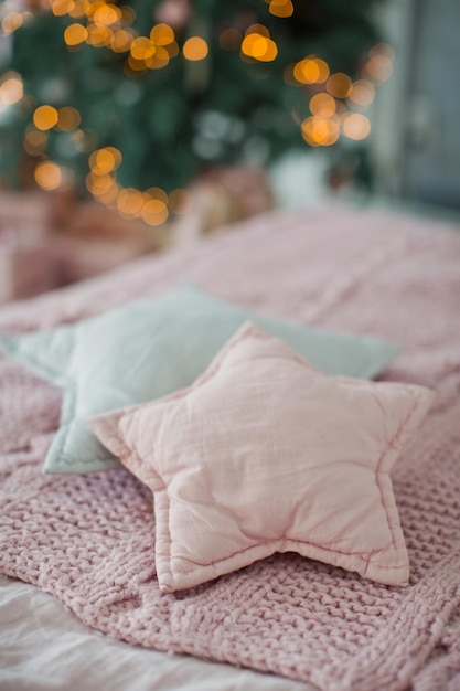 Bed met roze en grijs beddengoed en stervormige kussens Premium Foto
