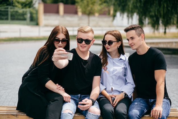 bedrijf van jonge vrienden met smartphones die in de stad lopen