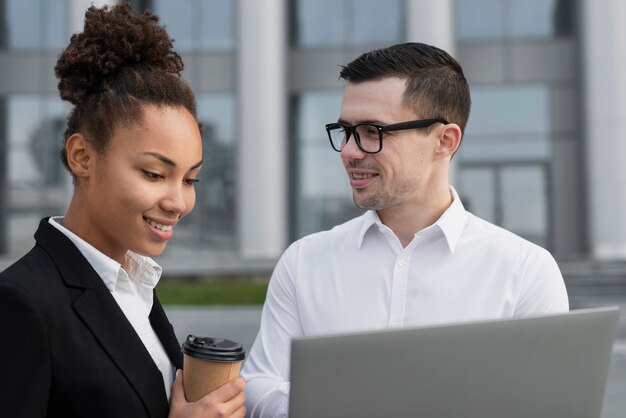 Bedrijfs mens die bij medewerker glimlacht