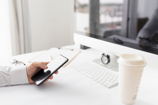 Bedrijfs mens die bij zijn bureau werkt en zijn laptop controleert