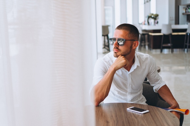 Bedrijfs mens met telefoonzitting bij de lijst