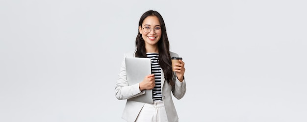 Bedrijfsfinanciën en werkgelegenheid vrouwelijk succesvol ondernemersconcept Zelfverzekerde knappe zakenvrouw in glazen en pak die afhaalkoffie drinkt en werklaptop draagt