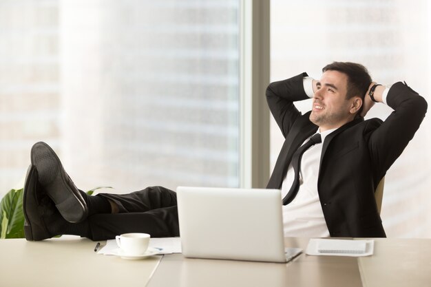 Bedrijfsleider die op het werk in bureau ontspannen