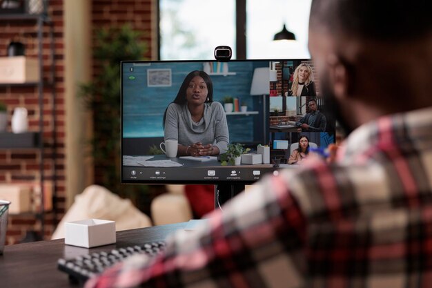 Bedrijfsmedewerker die op online videoconferentie praat, met behulp van teleconferentievergaderingen met collega's op webcam. Chatten op een videogesprek op afstand op de computer, thuis op afstand werken.