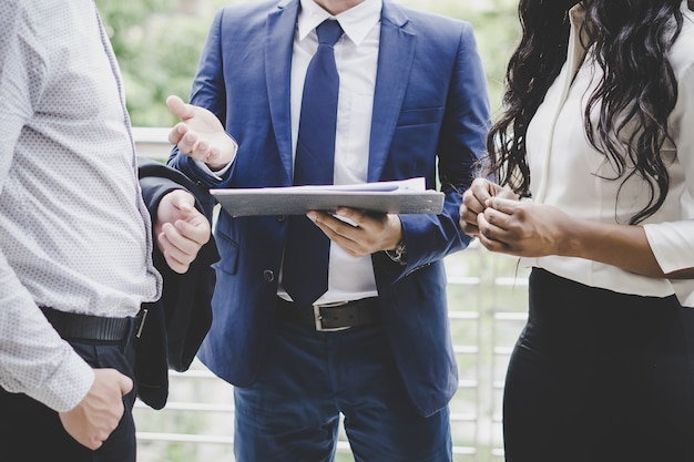 Bedrijfsmedewerkers die nieuwe ideeën bespreken en samen brainstormend nieuw projectdocument bekijken.