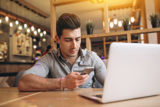 Bedrijfsmens die op de telefoon in een koffie spreken