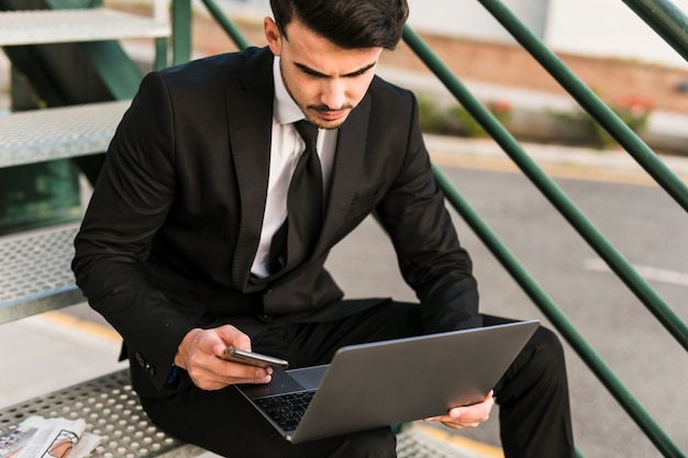 Gratis foto bedrijfsmens die zijn laptop met behulp van