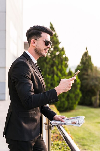 Bedrijfsmens die zijn telefoon met behulp van