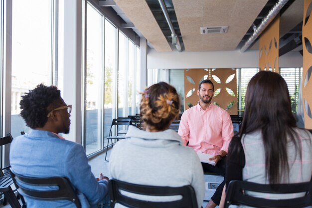 Bedrijfstrainer die ervaring met groep collega's deelt