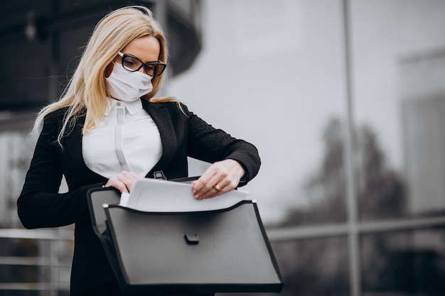 Bedrijfsvrouw die masker buiten het commerciële centrum dragen