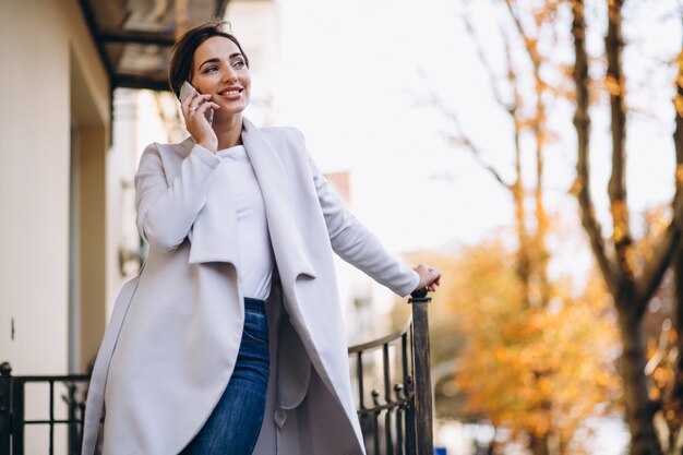 Bedrijfsvrouw die op de telefoon buiten spreken