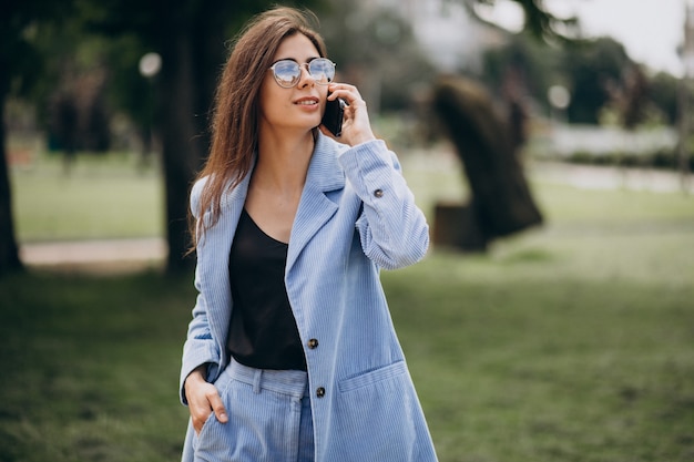 Bedrijfsvrouw die telefoon in park met behulp van