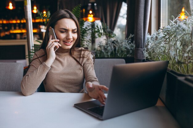 Bedrijfsvrouw het drinken koffie en het werken aan laptop in een koffie