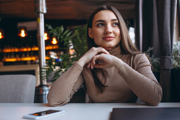 Bedrijfsvrouw het drinken koffie en het werken aan laptop in een koffie