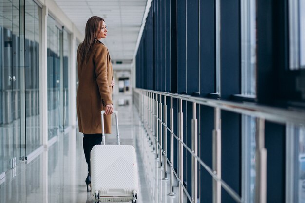 Bedrijfsvrouw met reiszak in luchthaven