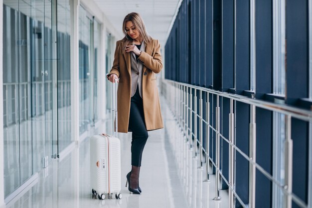 Bedrijfsvrouw met reiszak in luchthaven