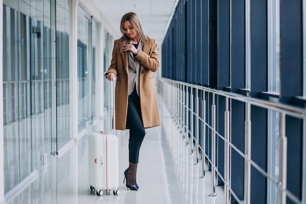 Bedrijfsvrouw met reiszak in luchthaven