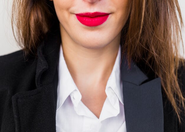 Bedrijfsvrouw met rode lippen in zwart kostuum