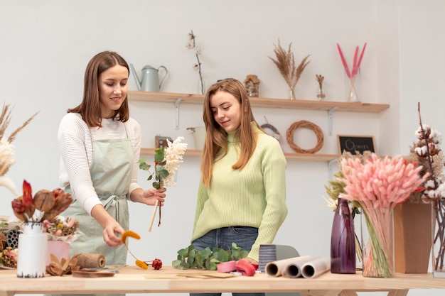 Bedrijfsvrouwen die een boeket van bloemen schikken