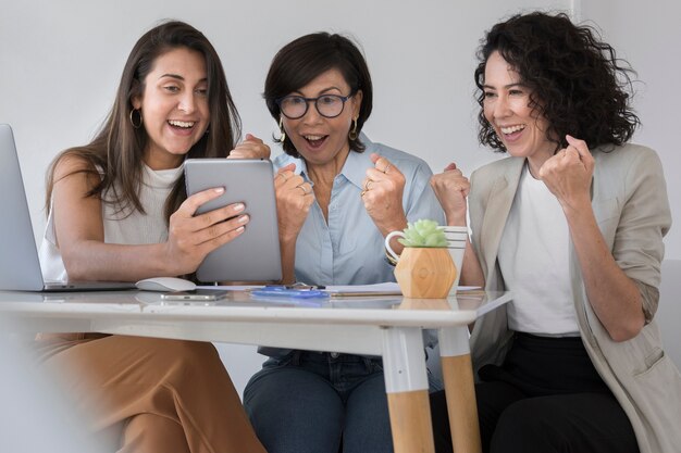 Bedrijfsvrouwen die iets bekijken grappig op de tablet