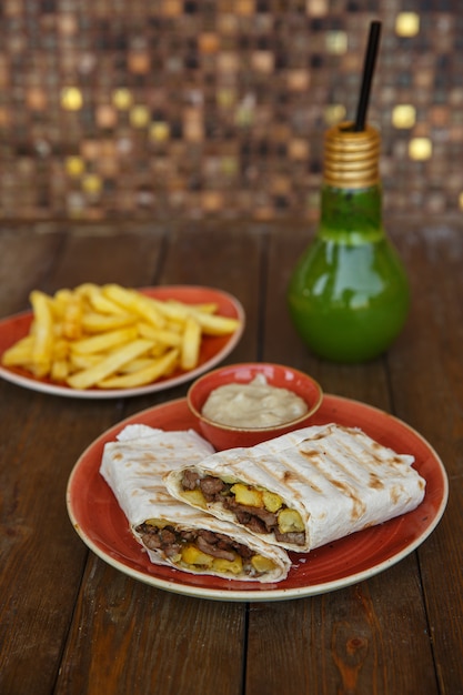 Gratis foto beef doner wrap in flatbread geserveerd met friet en mayonaise