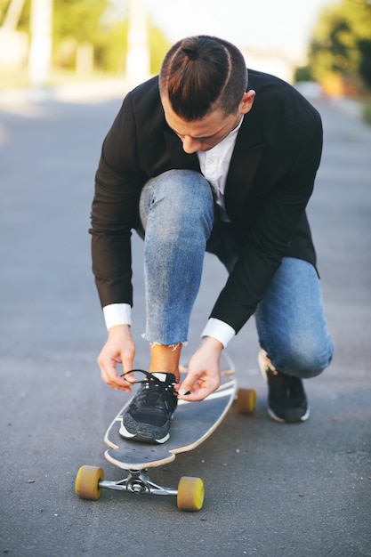 Beeld van een man met longboard die op weg gaat