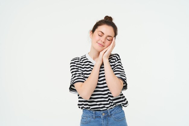Beeld van een tedere vrouw die jarenlang handen bij haar gezicht houdt en haar ogen sluit slaapt en glimlacht tijdens een dutje.