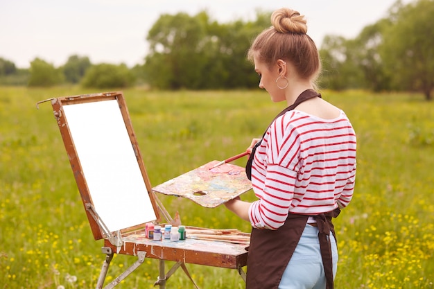 Beeld van vrouwelijke kunstenaar die met waterverf het schilderen werkt