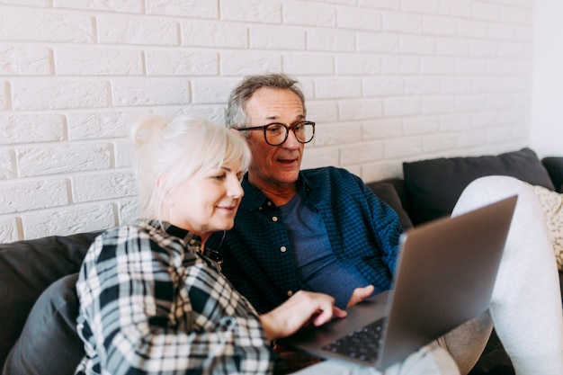 Gratis foto bejaard paar in bejaardentehuis die laptop met behulp van