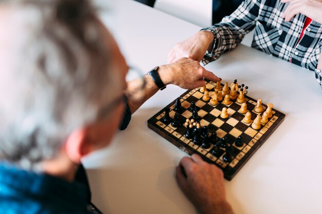 Bejaard paar in bejaardentehuis het spelen schaak