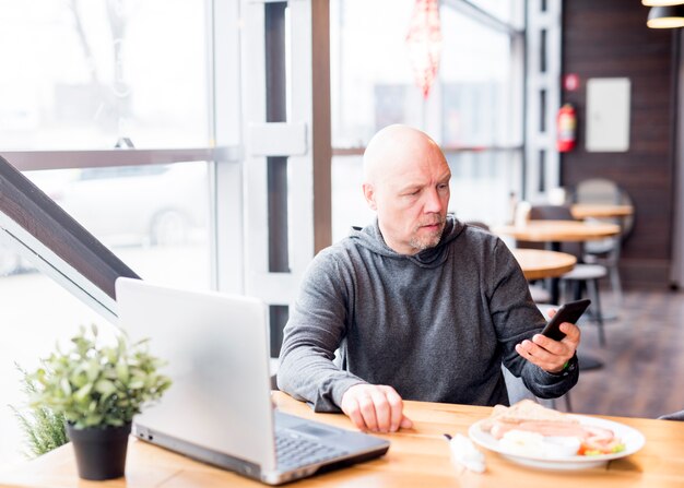 Bejaarde die mobiele telefoon met behulp van