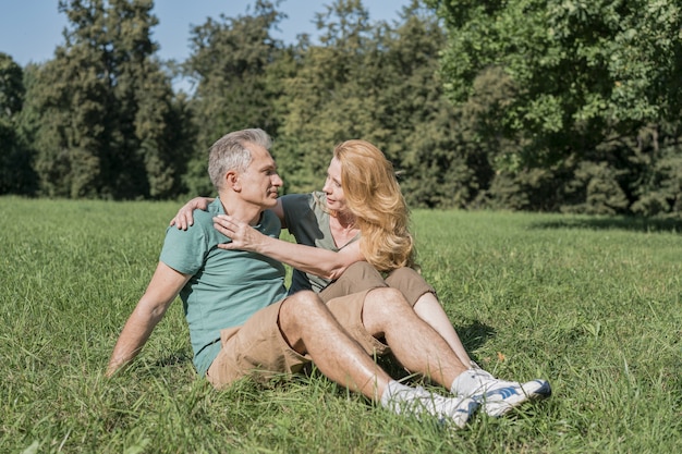 Bejaarde echtpaar zitten samen op gras