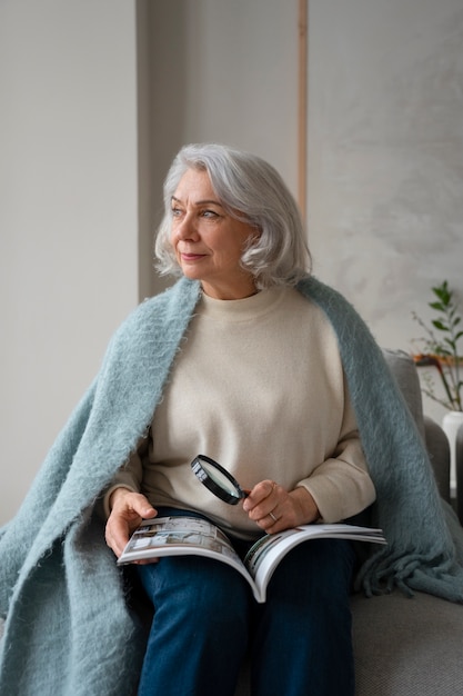 Bejaarde vrouw leest met behulp van een vergrootglas om te lezen