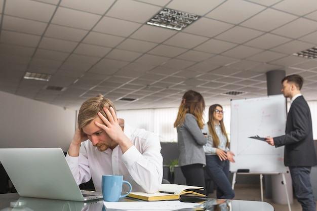 Gratis foto beklemtoonde zakenmanzitting in bureau