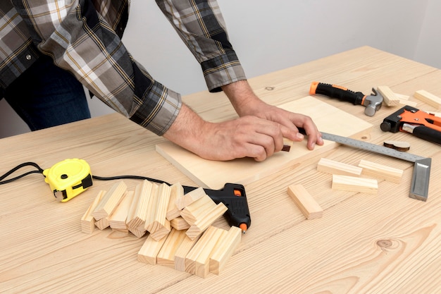 Bekwame timmermansarbeider die zijn hulpmiddelen op hout gebruikt