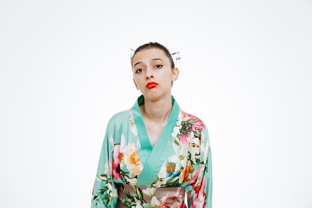 Beledigde vrouw in traditionele Japanse kimono met droevige uitdrukking op wit