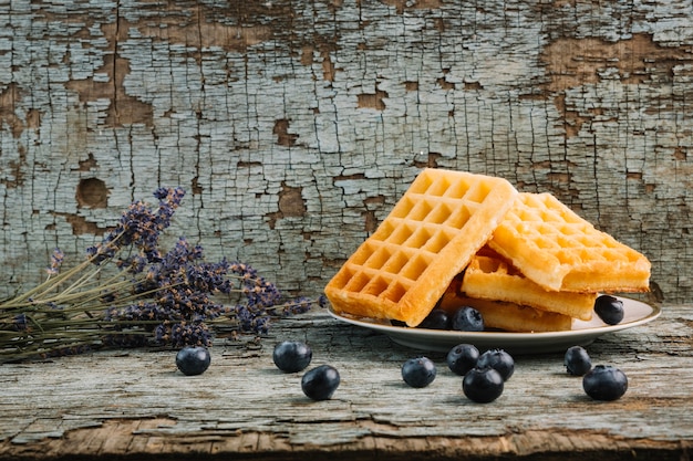 Gratis foto belgische wafels met bessen dichtbij boeket