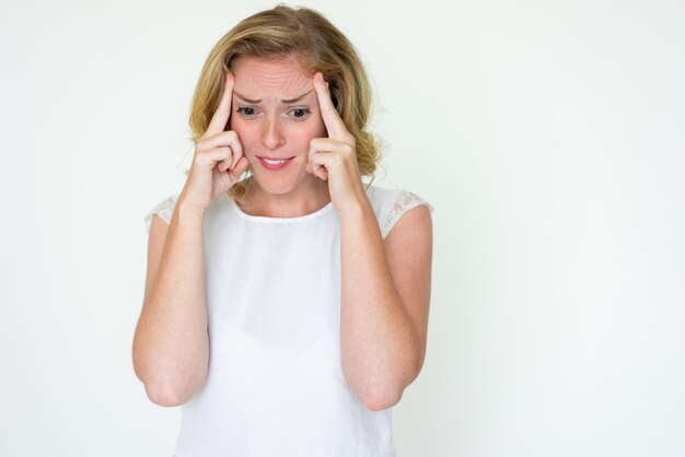 Benadrukt jonge vrouw aanraken van tempels