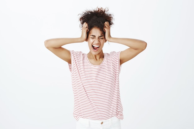 Gratis foto benadrukt vrouw met afro kapsel poseren in de studio