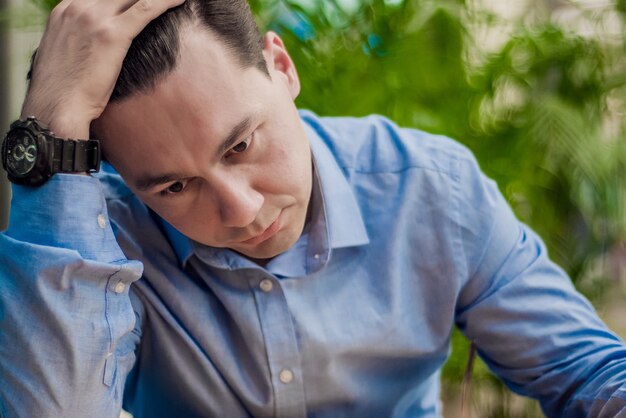 Benadrukte man. Emotie portret, alleenstaand man. Binnenshuis portret. Zakenman in depressie met handen op het voorhoofd