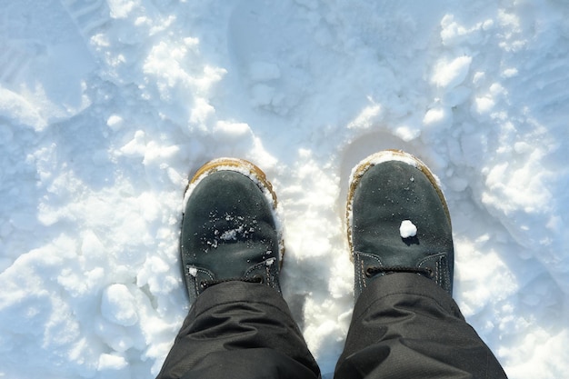 Benen in laarzen op sneeuw, bovenaanzicht