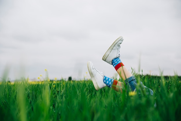 Benen in witte schoenen en boven gras