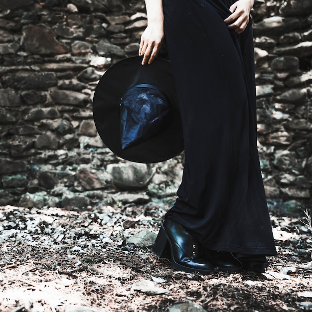 Gratis foto benen van de vrouw in zwarte jurk met hoed