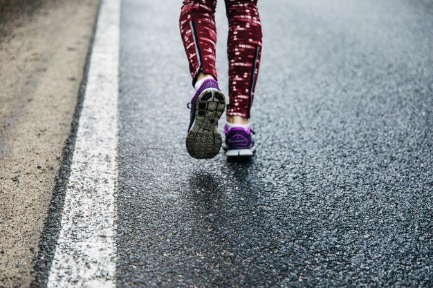 Benen van vrouw die op weg loopt