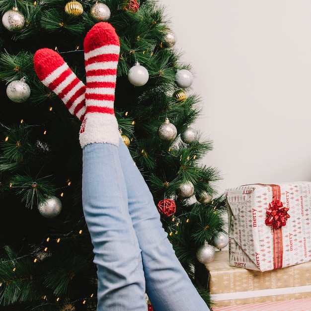 Gratis foto benen van vrouw voor kerstboom