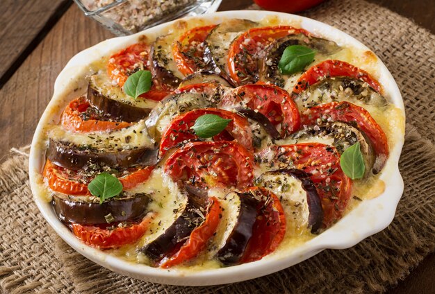 Bereid gratin schotel rauwe aubergine met mozzarella en tomaten