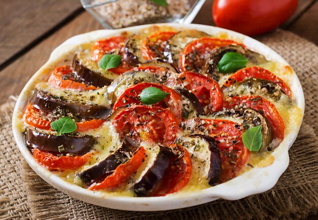 Bereid gratin schotel rauwe aubergine met mozzarella en tomaten