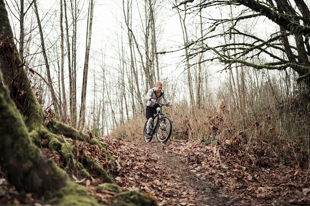 Bergfietser die de fiets berijden op bossleep in de herfst