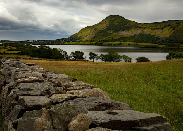 Gratis foto bertraghboy bay bedekt met groen onder een bewolkte hemel in connemara in ierland